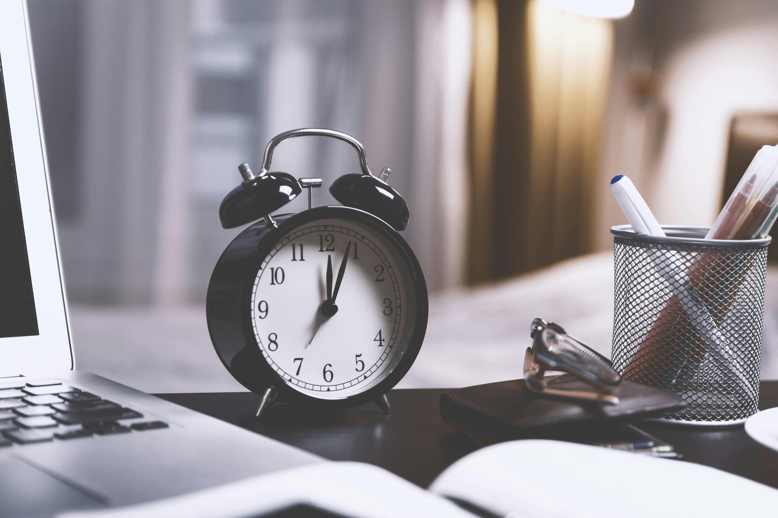 Clock on desk with laptop
